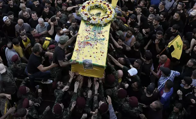 FILE - Hezbollah fighters carry a coffin during a funeral procession in the southern suburb of Beirut, Lebanon, Sept. 18, 2024. (AP Photo/Bilal Hussein, File)