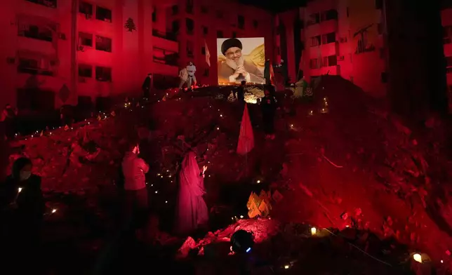 FILE - A woman lights candles at the site where former Hezbollah leader Hassan Nasrallah was killed by Israeli airstrikes in the southern suburb of Beirut, Lebanon, Nov. 30, 2024. (AP Photo/Hussein Malla, File)