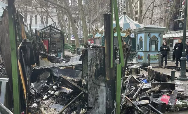 This image provided by the Fire Department of New York, FDNY personnel investigates the aftermath of a fire at an outdoor holiday market in Bryant Park on Friday, Dec. 27, 2024 in New York. (FDNY via AP)