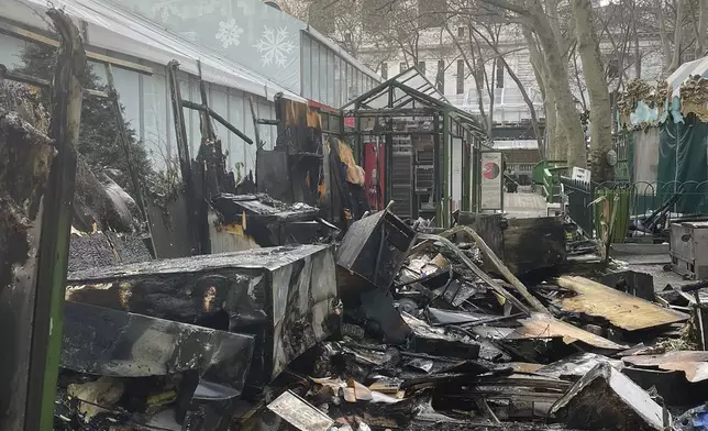 This image provided by the Fire Department of New York, FDNY personnel investigates the aftermath of a fire at an outdoor holiday market in Bryant Park on Friday, Dec. 27, 2024 in New York. (FDNY via AP)