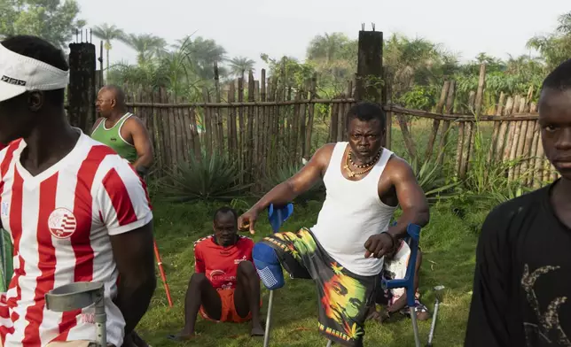 Farming trainees who have been amputated during Sierra Leone's civil war from 1991-2002, do warmup exercises before starting their day at the Farming on Crutches initiative in Freetown, Sierra Leone, Wednesday, Sept. 25, 2024. (AP Photo/Jack Thompson)