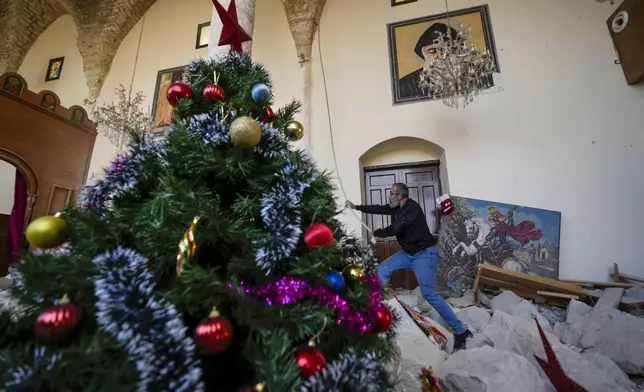 Georges Elia rings the bells after he decorated a Christmas tree inside St. George Melkite Catholic Church, that was destroyed by Israeli airstrike, in the town of Dardghaya in southern Lebanon, Sunday, Dec. 22, 2024. (AP Photo/Hassan Ammar)