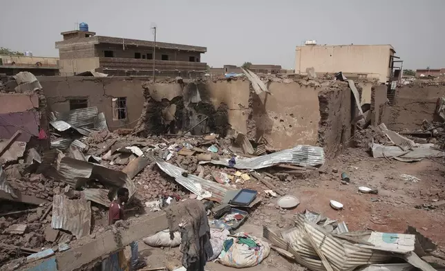 File - A man walks by a house hit in recent fighting in Khartoum, Sudan, an area torn by fighting between the military and the notorious paramilitary Rapid Support Forces, April 25, 2023. (AP Photo/Marwan Ali, File)