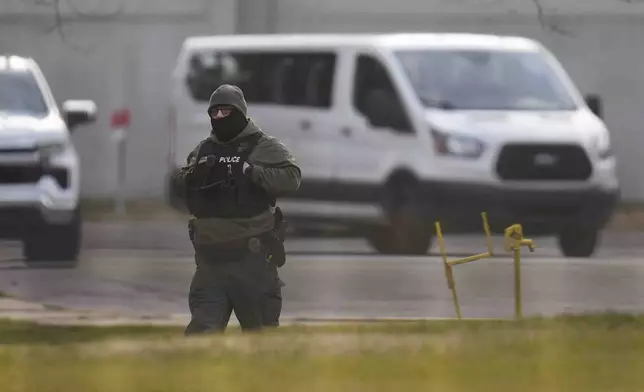 A police officer walks outside of Indiana State Prison on Tuesday, Dec. 17, 2024, in Michigan City, Ind., where, barring last-minute court action or intervention by Gov. Eric Holcomb, Joseph Corcoran, 49, convicted in the 1997 killings of his brother and three other people, is scheduled to be put to death by lethal injection before sunrise Wednesday, Dec. 18. (AP Photo/Erin Hooley)