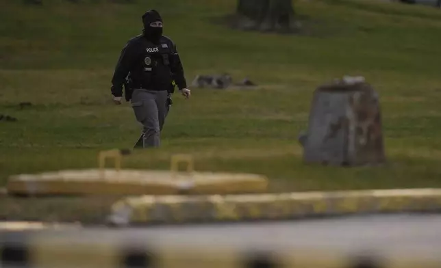 A police officer walks outside of Indiana State Prison on Tuesday, Dec. 17, 2024, in Michigan City, Ind., where, barring last-minute court action or intervention by Gov. Eric Holcomb, Joseph Corcoran, 49, convicted in the 1997 killings of his brother and three other people, is scheduled to be put to death by lethal injection before sunrise Wednesday, Dec. 18. (AP Photo/Erin Hooley)