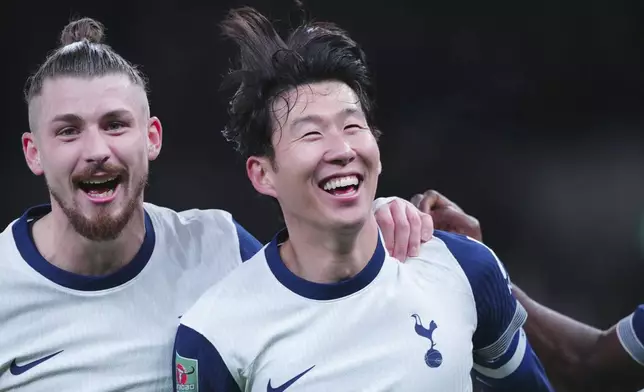 Tottenham's Son Heung-min, right, celebrates after scoring his side's fourth goal during the English League Cup quarter-final soccer match between Tottenham and Manchester United, at the Tottenham Hotspur Stadium in London, Thursday, Dec. 19, 2024. (AP Photo/Dave Shopland )