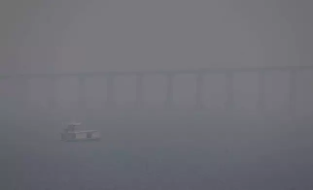 FILE - A boat navigates the Negro River amid smoke from wildfires in Manaus, Amazonas state, Brazil, Aug. 27, 2024. (AP Photo/Edmar Barros, File)