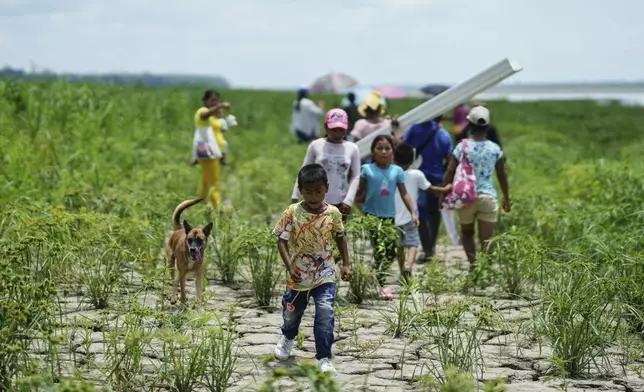 FILE - People from the Tikuna Indigenous community walk to receive aid from an NGO amid a drought near the Amazon River in Loma Linda, on the outskirts of Leticia, Colombia, Oct. 20, 2024. (AP Photo/Ivan Valencia, File)