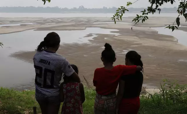 FILE - Residents look out at the Madeira River, a tributary of the Amazon River amid a drought in Humaita, Amazonas state, Brazil, Sept. 7, 2024. (AP Photo/Edmar Barros, File)