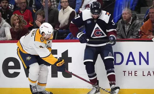 Nashville Predators left wing Filip Forsberg, left, fights for control of the puck with Colorado Avalanche center Casey Mittelstadt in the first period of an NHL hockey game Saturday, Dec. 14, 2024, in Denver. (AP Photo/David Zalubowski)