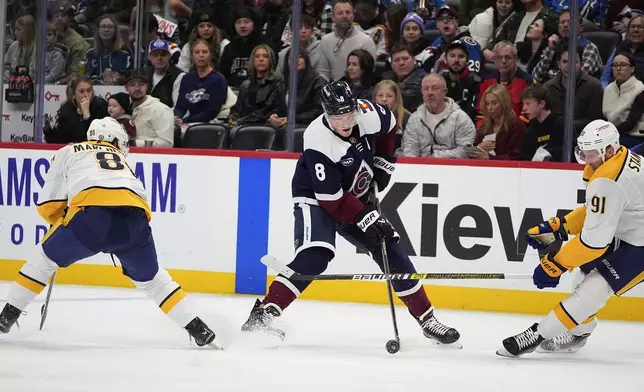 Colorado Avalanche defenseman Cale Makar, center, drives between Nashville Predators centers Jonathan Marchessault, left, and Steven Stamkos in the first period of an NHL hockey game Saturday, Dec. 14, 2024, in Denver. (AP Photo/David Zalubowski)