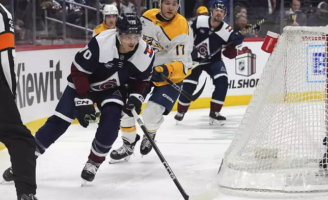 Colorado Avalanche defenseman Sam Malinski, left, pursues the puck with Nashville Predators center Mark Jankowski in the second period of an NHL hockey game Saturday, Dec. 14, 2024, in Denver. (AP Photo/David Zalubowski)