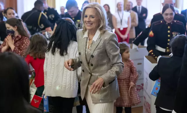 First lady Jill Biden sorts toys as she hosts a Toys for Tots event with Marine Corps families in the East Room at the White House in Washington, Friday, Dec. 13, 2024. (AP Photo/Mark Schiefelbein)