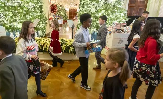 Children of Marine Corps families sort toys during a Toys for Tots event with first lady Jill Biden in the East Room at the White House in Washington, Friday, Dec. 13, 2024. (AP Photo/Mark Schiefelbein)