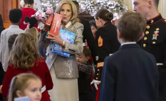 First lady Jill Biden sorts toys as she hosts a Toys for Tots event with Marine Corps families in the East Room at the White House in Washington, Friday, Dec. 13, 2024. (AP Photo/Mark Schiefelbein)