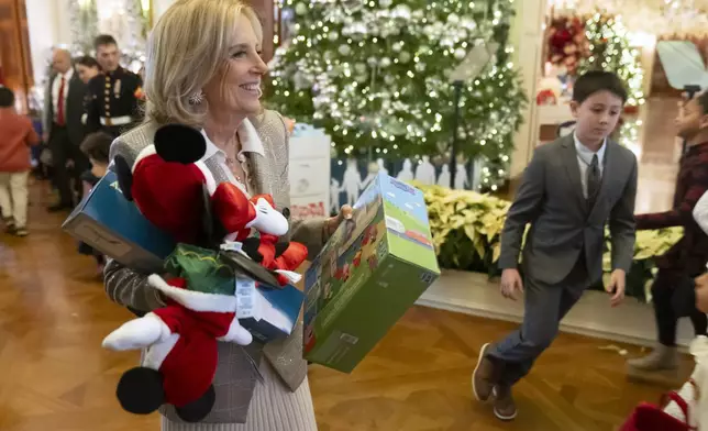 First lady Jill Biden sorts toys as she hosts a Toys for Tots event with Marine Corps families in the East Room at the White House in Washington, Friday, Dec. 13, 2024. (AP Photo/Mark Schiefelbein)