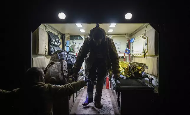 An injured Ukrainian serviceman walks out of an ambulance at Medical Service "Ulf" of the 108th Separate Battalion "Da Vinci Wolves" on Pokrovsk direction, Ukraine, Tuesday, Dec. 24, 2024. (AP Photo/Evgeniy Maloletka)