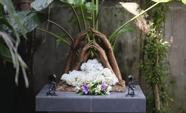 Floral tributes sit at a monument for the victims of 2004 Indian ocean tsunami at the residence of Jayarasa Abilash known as Baby 81 after he was swept away by the 2004 Indian ocean tsunami in Kurukkalmadam, Sri Lanka, Tuesday, Dec. 17, 2024. (AP Photo/Eranga Jayawardena)