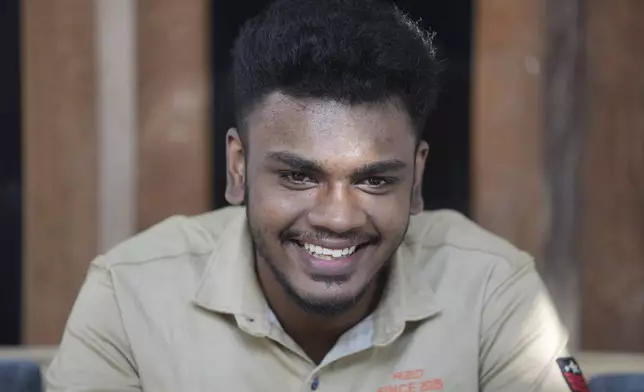 Jayarasa Abilash, known as Baby 81 after he was swept away by the 2004 Indian ocean tsunami, smiles as he speaks to Associated Press at his residence in Kurukkalmadam, Sri Lanka, Tuesday, Dec. 17, 2024. (AP Photo/Eranga Jayawardena)