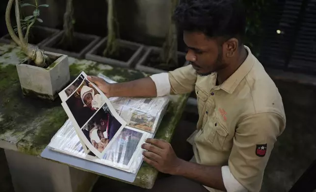 Jayarasa Abilash, known as Baby 81 after he was swept away by the 2004 Indian ocean tsunami goes through his photo album at his residence in Kurukkalmadam, Sri Lanka, Tuesday, Dec. 17, 2024. (AP Photo/Eranga Jayawardena)