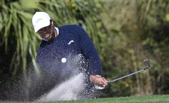 Tiger Woods hits out of a bunker onto the fourth green during the first round of the PNC Championship golf tournament, Saturday, Dec. 21, 2024 in Orlando. (AP Photo/Phelan M. Ebenhack)