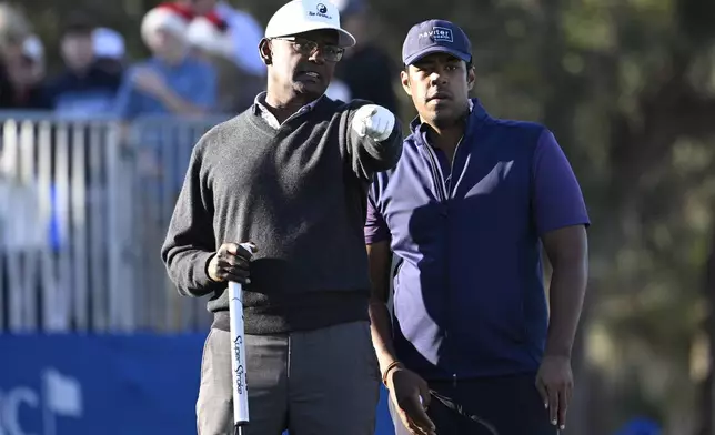 Vijay Singh, left, and his son Qass Singh line up their putt on the 18th green during the first round of the PNC Championship golf tournament, Saturday, Dec. 21, 2024, in Orlando, Fla. (AP Photo/Phelan M. Ebenhack)