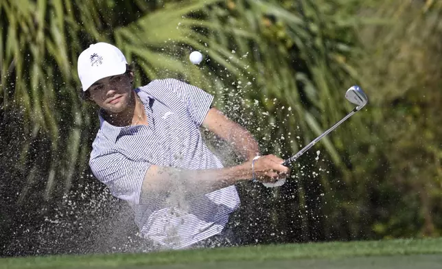 Charlie Woods hits out of a bunker onto the fourth green during the first round of the PNC Championship golf tournament, Saturday, Dec. 21, 2024 in Orlando. (AP Photo/Phelan M. Ebenhack)