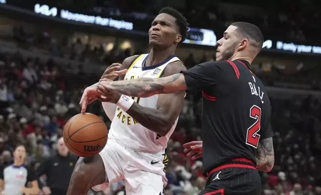 Chicago Bulls' Lonzo Ball (2) knocks the ball out of the hands of Indiana Pacers' Bennedict Mathurin onto his leg and out of bounds during the second half of an NBA basketball game Friday, Dec. 6, 2024, in Chicago. (AP Photo/Charles Rex Arbogast)