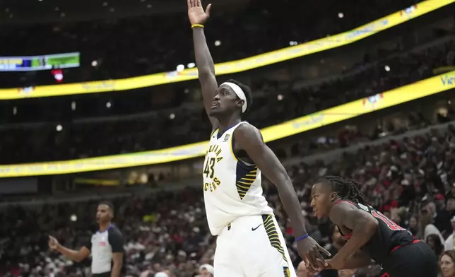 Indiana Pacers' Pascal Siakam signals his three-point basket as Chicago Bulls' Ayo Dosunmu watches during the second half of an NBA basketball game Friday, Dec. 6, 2024, in Chicago. (AP Photo/Charles Rex Arbogast)