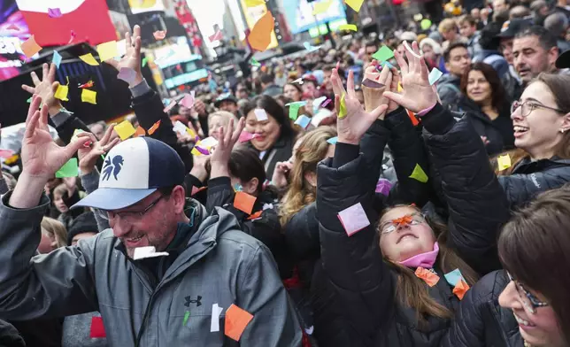 People in the crowd catch confetti ahead of New Year's Eve in Times Square, Sunday, Dec. 29, 2024, in New York. (AP Photo/Heather Khalifa)