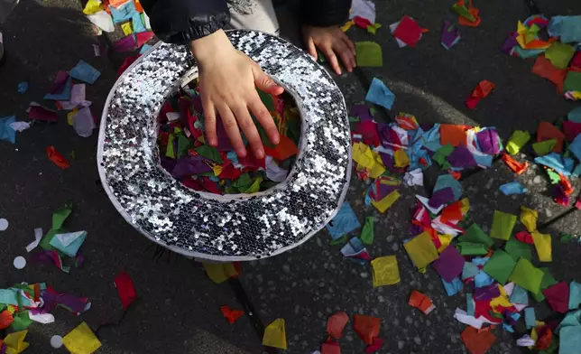 Kids collect confetti off the ground ahead of New Years Eve in Times Square, Sunday, Dec. 29, 2024, in New York. (AP Photo/Heather Khalifa)