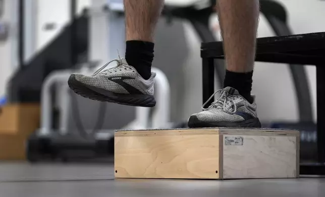 Jacob Bullard steps off a box as part of his physical therapy at WashU, Monday, Dec. 16, 2024, in St. Louis. (AP Photo/Jeff Roberson)