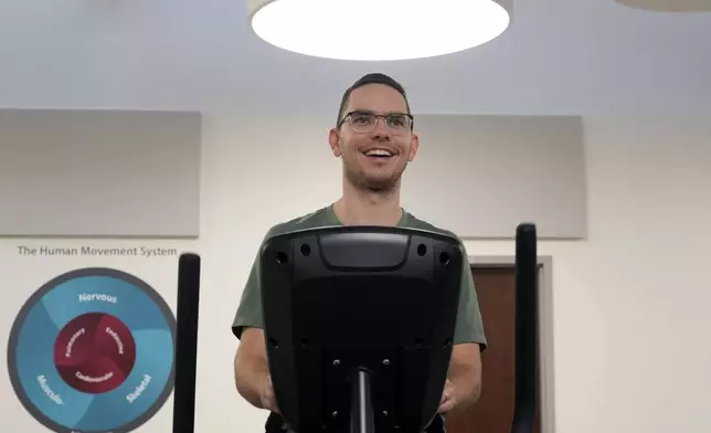 Jacob Bullard warms up on an elliptical machine while undergoing physical therapy at WashU, Monday, Dec. 16, 2024, in St. Louis. (AP Photo/Jeff Roberson)