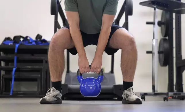 Jacob Bullard lifts a weight as part of his physical therapy at WashU, Monday, Dec. 16, 2024, in St. Louis. (AP Photo/Jeff Roberson)