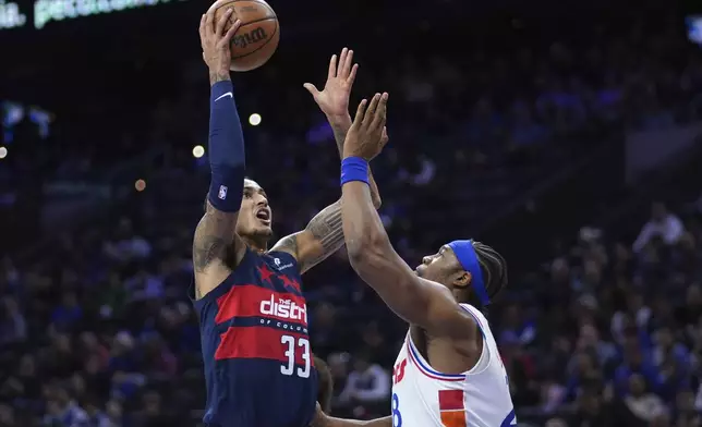 Washington Wizards' Kyle Kuzma, left, goes up for a shot against Philadelphia 76ers' Guerschon Yabusele during the first half of an NBA basketball game, Wednesday, Jan. 8, 2025, in Philadelphia. (AP Photo/Matt Slocum)