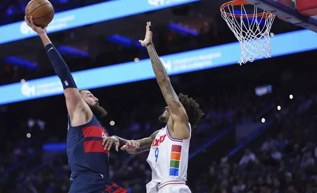 Washington Wizards' Jonas Valanciunas, left, tries to dunk against Philadelphia 76ers' Kelly Oubre Jr. during the first half of an NBA basketball game, Wednesday, Jan. 8, 2025, in Philadelphia. (AP Photo/Matt Slocum)