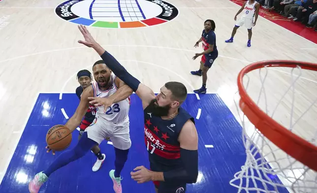 Philadelphia 76ers' Eric Gordon (23) goes up for a shot against Washington Wizards' Jonas Valanciunas (17) during the first half of an NBA basketball game, Wednesday, Jan. 8, 2025, in Philadelphia. (AP Photo/Matt Slocum)