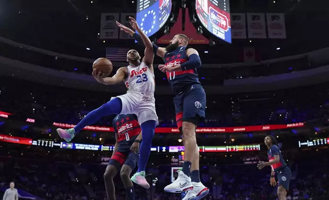 Philadelphia 76ers' Eric Gordon (23) goes up for a shot against Washington Wizards' Jonas Valanciunas (17) during the first half of an NBA basketball game, Wednesday, Jan. 8, 2025, in Philadelphia. (AP Photo/Matt Slocum)