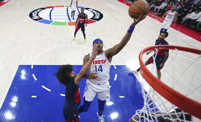 Philadelphia 76ers' Ricky Council IV, right, goes up for a shot against Washington Wizards' Kyshawn George during the first half of an NBA basketball game, Wednesday, Jan. 8, 2025, in Philadelphia. (AP Photo/Matt Slocum)