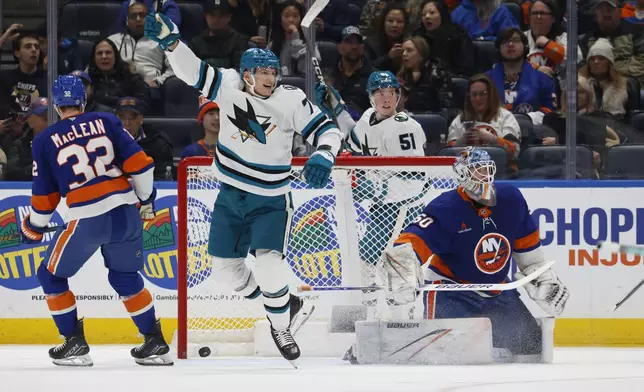 San Jose Sharks center Nico Sturm (7) and right wing Collin Graf (51) react after a goal by right wing Barclay Goodrow (not shown) against New York Islanders goaltender Marcus Hogberg (50) during the second period of an NHL hockey game, Saturday, Jan. 18, 2025, in Elmont, N.Y. (AP Photo/Corey Sipkin).