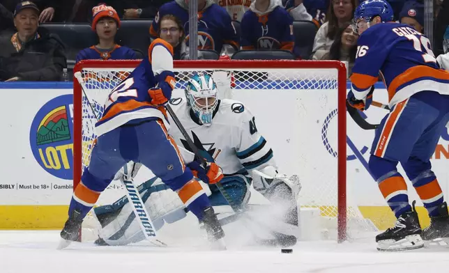 New York Islanders center Kyle MacLean (32) shoots on San Jose Sharks goaltender Alexandar Georgiev (40) during the first period of an NHL hockey game, Saturday, Jan. 18, 2025, in Elmont, N.Y. (AP Photo/Corey Sipkin).