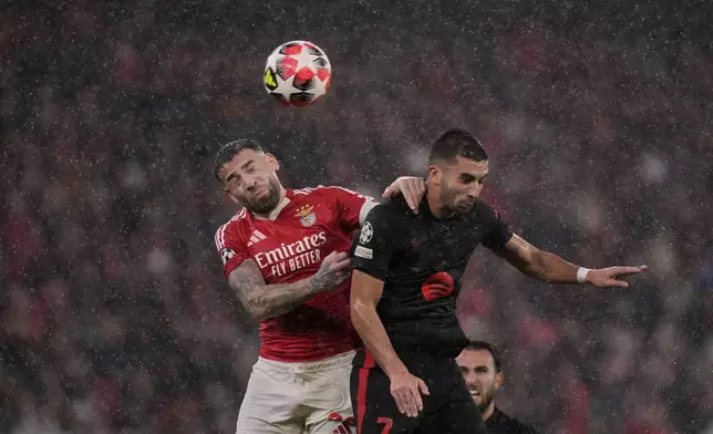 Benfica's Nicolas Otamendi jumps for the ball against Barcelona's Ferran Torres during a Champions League opening phase soccer match between SL Benfica and FC Barcelona at the Luz stadium in Lisbon, Tuesday, Jan. 21, 2025. (AP Photo/Armando Franca)