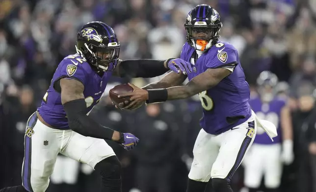 Baltimore Ravens quarterback Lamar Jackson, right, fakes a hand off to running back Derrick Henry during the first half of an NFL football game against the Cleveland Browns Saturday, Jan. 4, 2025, in Baltimore. (AP Photo/Stephanie Scarbrough)