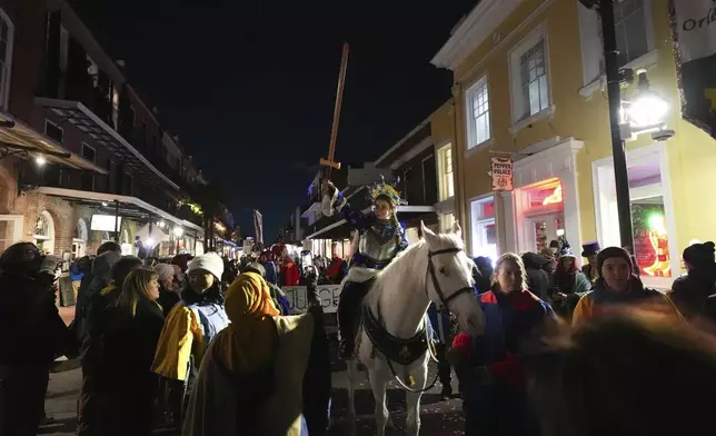 A person dressed as Joan of Arc holds a sword on-top of a horse during the annual Krewe de Jeanne d'Arc parade, kicking off the Mardi Gras season, in New Orleans, Monday, Jan. 6, 2025. (AP Photo/Gerald Herbert)