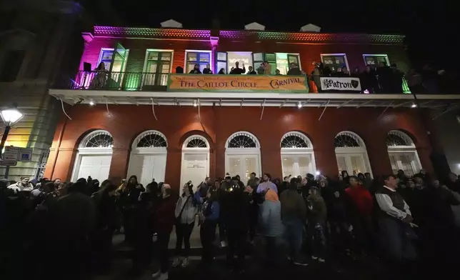 Parade attendees toast to victims of the deadly New Years truck attack, during the annual Krewe de Jeanne d'Arc parade, kicking off the Mardi Gras season, in New Orleans, Monday, Jan. 6, 2025. (AP Photo/Gerald Herbert)