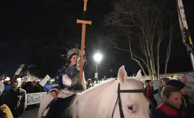 A person dressed as Joan of Arc rides a horse during the annual Krewe de Jeanne d'Arc parade, kicking off the Mardi Gras season, in New Orleans, Monday, Jan. 6, 2025. (AP Photo/Gerald Herbert)