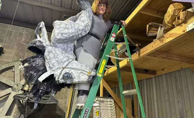 Antoinette de Alteriis gathers props in preparation for the Joan of Arc parade Monday, Jan. 6, 2025, in New Orleans' French Quarter. (AP Photo/Jack Brook)