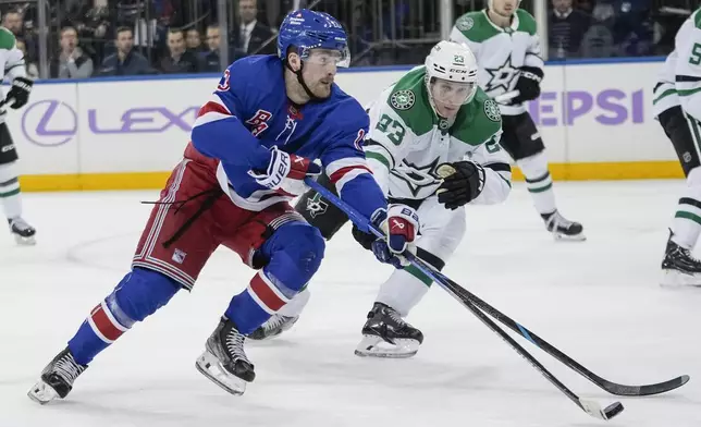 New York Rangers' Alexis Lafrenière (13) drives past Dallas Stars' Esa Lindell (23) during the second period of an NHL hockey game, Tuesday, Jan. 7, 2025, in New York. (AP Photo/Frank Franklin II)