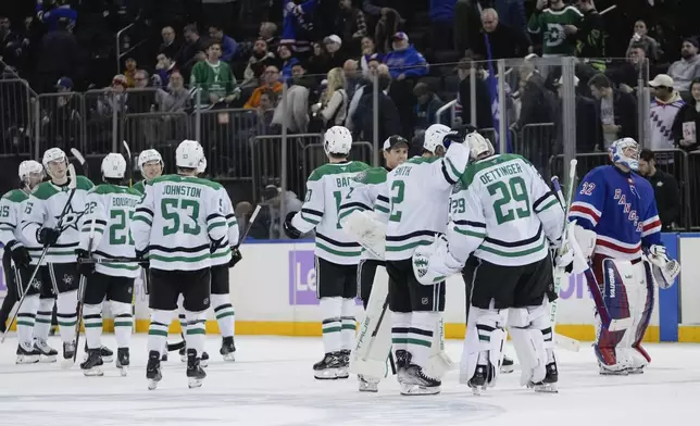 Dallas Stars goaltender Jake Oettinger (29) celebrates with teammates as New York Rangers goaltender Jonathan Quick (32) skates past them after an NHL hockey game, Tuesday, Jan. 7, 2025, in New York. (AP Photo/Frank Franklin II)