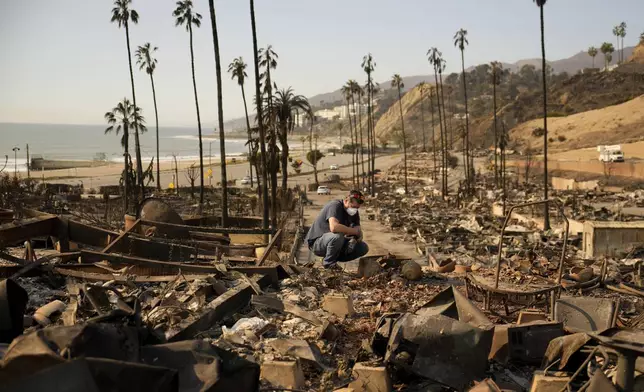 Kevin Marshall sifts through his mother's fire-ravaged property in the the Palisades Fire in the Pacific Palisades neighborhood of Los Angeles, Saturday, Jan. 11, 2025. (AP Photo/John Locher)